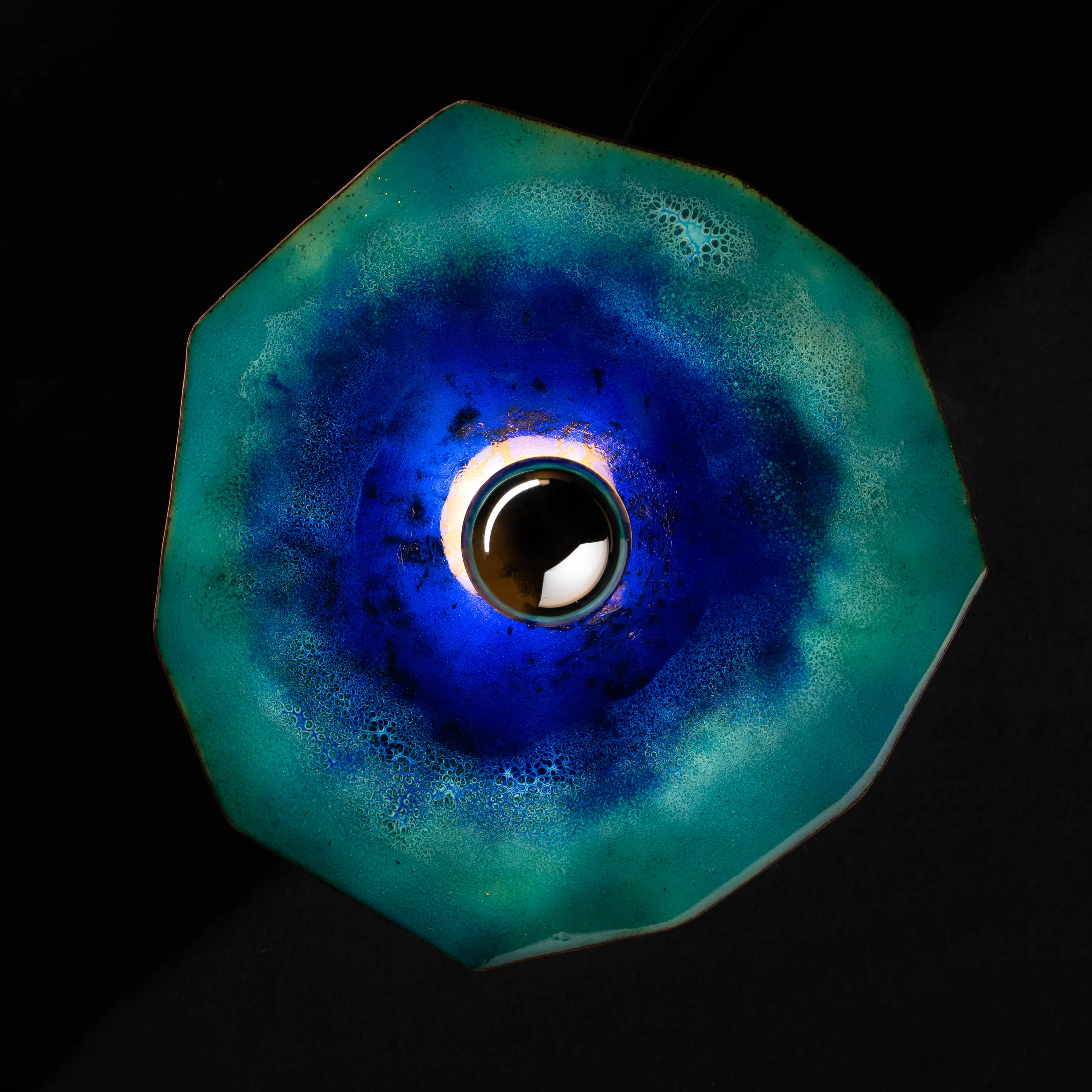 Luminaire en émail bleu profond et vert présenté de face sur fond noir