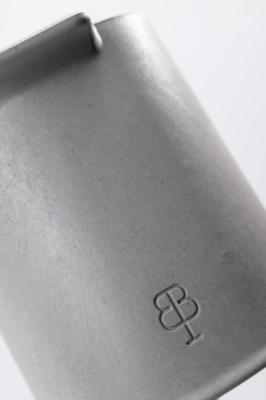 Très gros plan sur la matière grise du support de bbb La Brosse et son monogramme en relief
