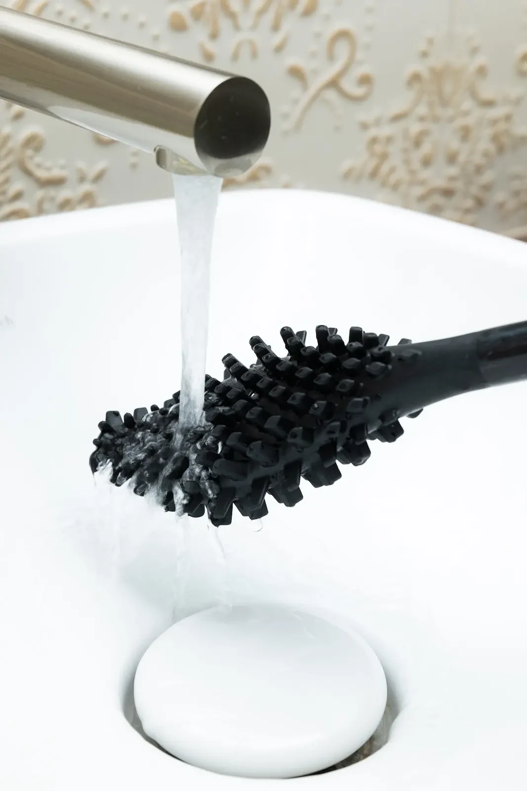 Tête noire de bbb La Brosse rincée sous un filet d’eau dans un lavabo blanc