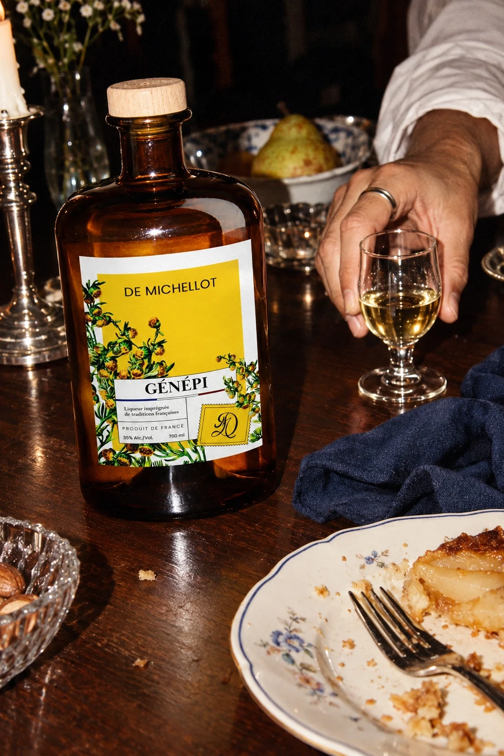 Génépi De Michellot en fin de dîner, une main saisit un verre près d’une assiette à dessert, flash direct — scène générée