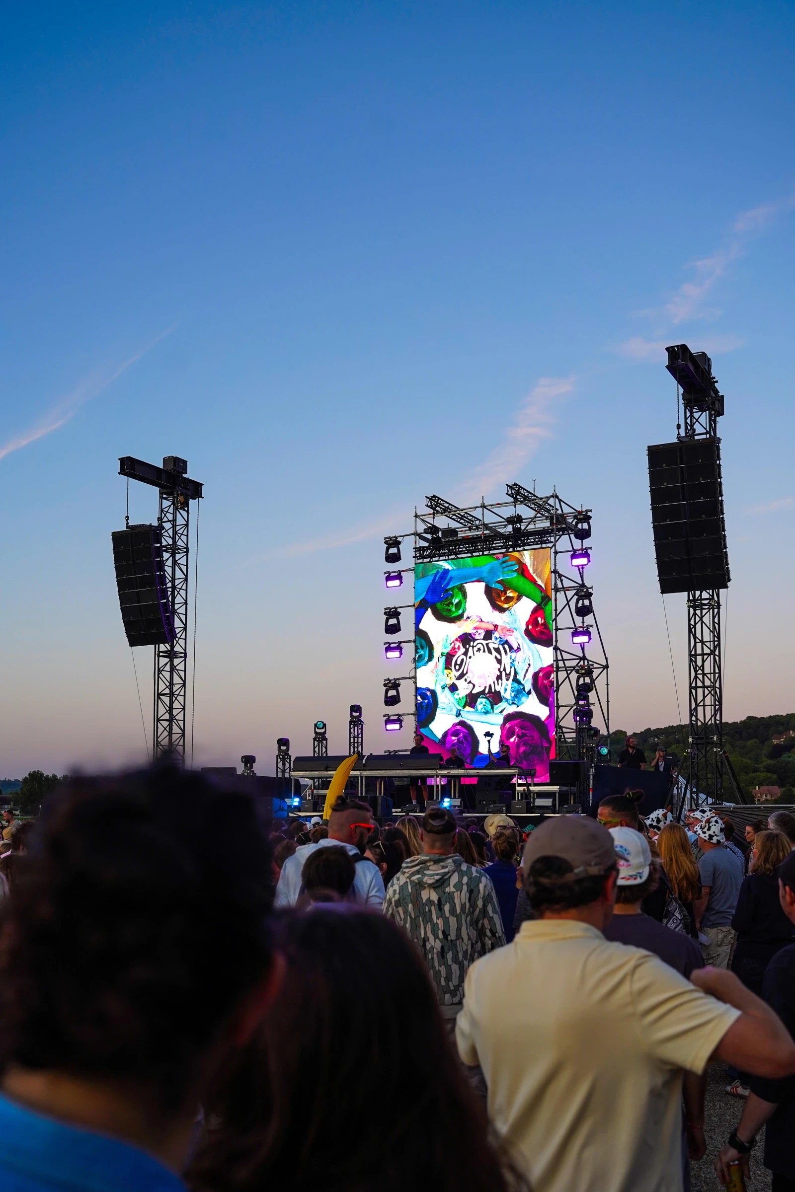 Festivaliers face à la scène extérieure au crépuscule, sous un ciel bleu — Gärten on the Beach, première édition 2025. Photographie de Tom Radday.