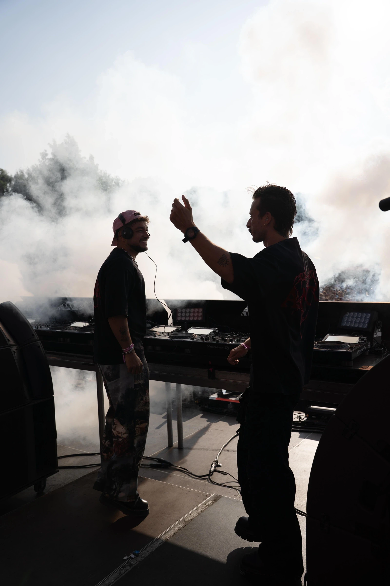 Deux artistes derrière les platines sur scène, dans la fumée et la lumière — Gärten on the Beach, première édition 2025. Photographie de Tom Radday.