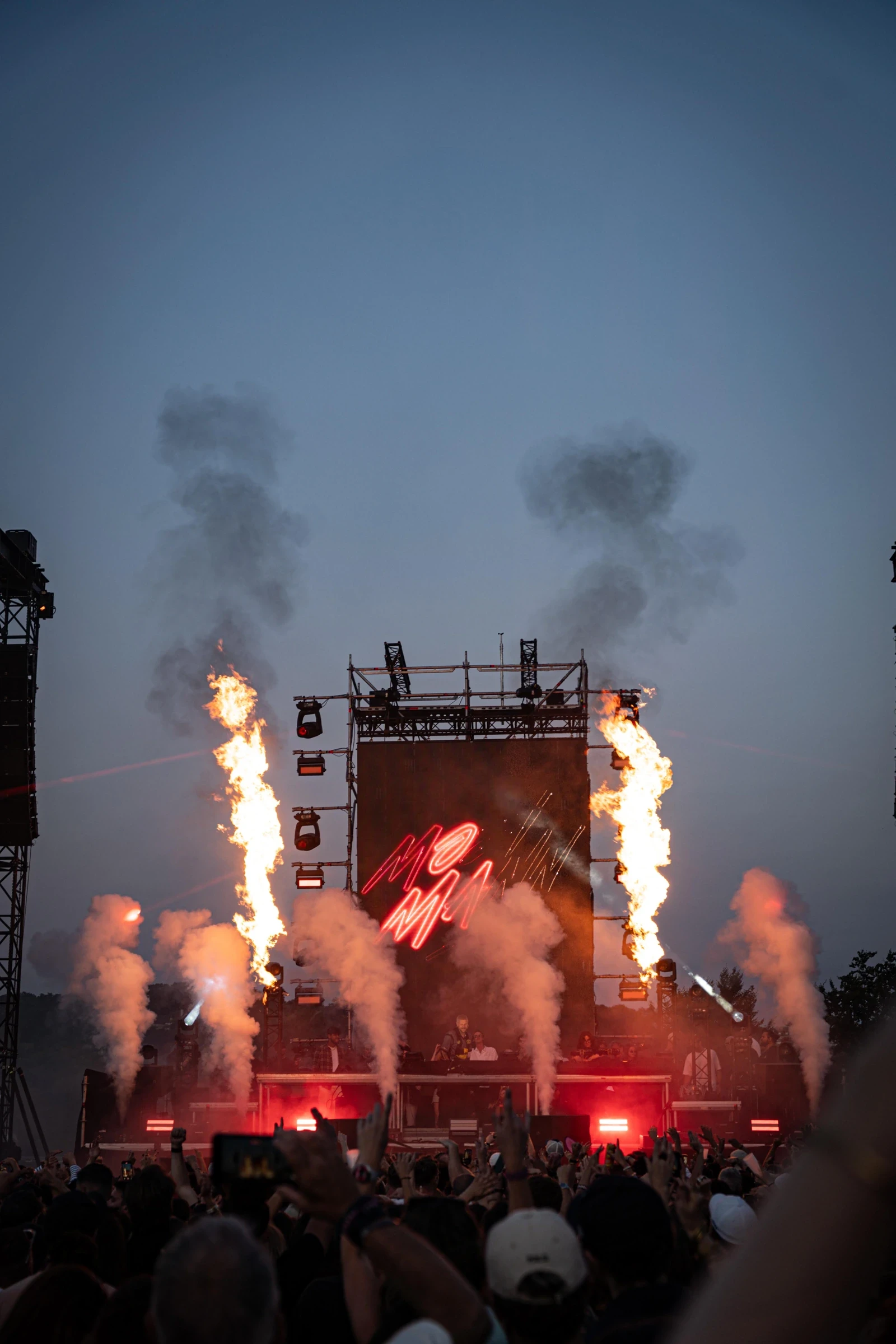 Scène extérieure avec jets de flammes et public au coucher du soleil — Gärten on the Beach, première édition 2025. Photographie de Tom Radday.