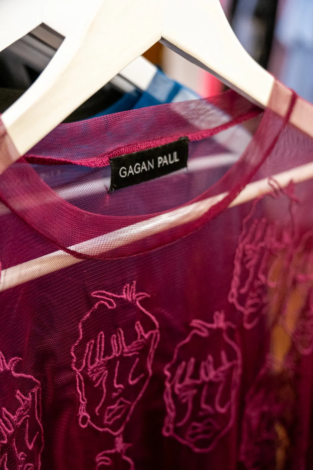 Pièce Gagan Paul en maille rose transparente sur cintre, avec étiquette noire et broderies