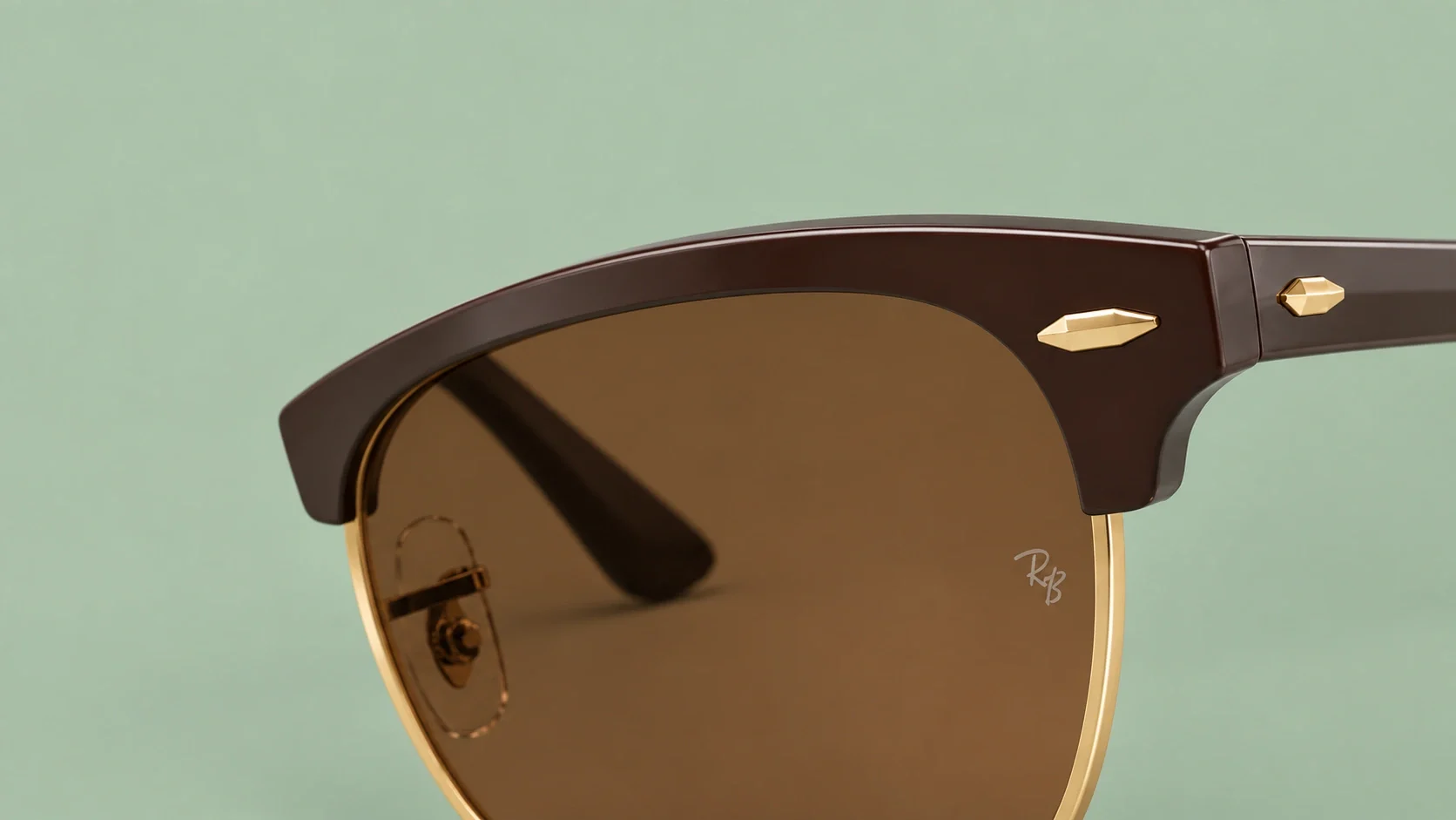 Très gros plan d’une monture brune et dorée sur fond sauge, composition générée à partir d’une story de L’Opticien de Chantilly