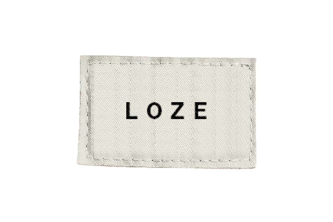 Étiquette textile blanche LOZE portant le mot-signe noir sur fond clair