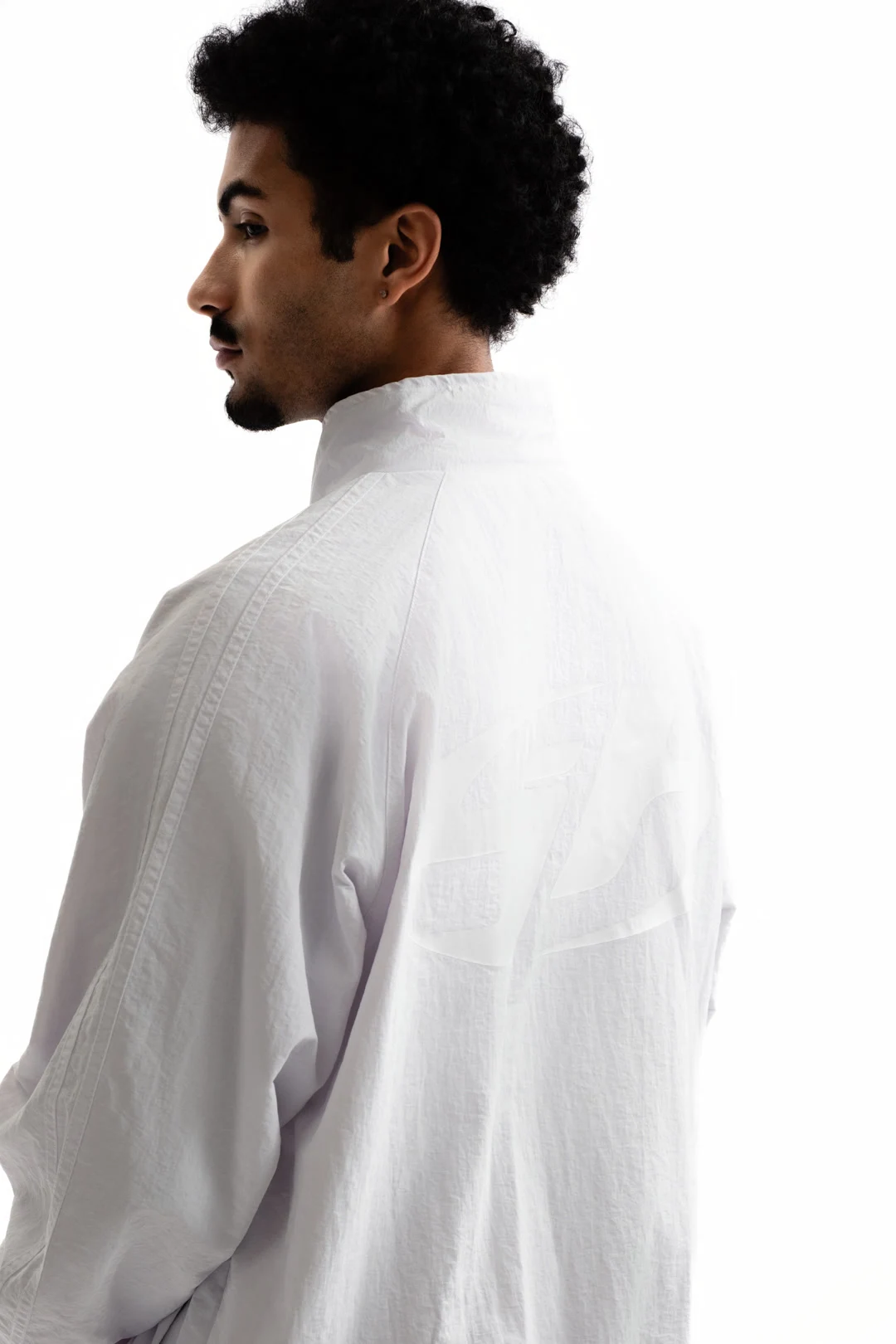 Modèle vu de dos portant une veste blanche Sixty House sur fond clair