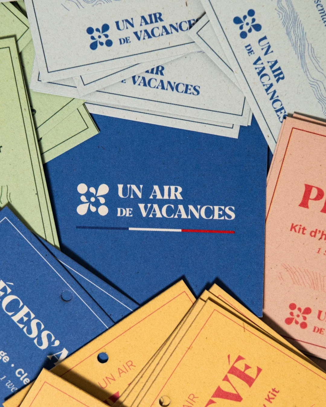 Détail du système graphique Un Air de Vacances sur des étiquettes bleues, jaunes, vertes et roses